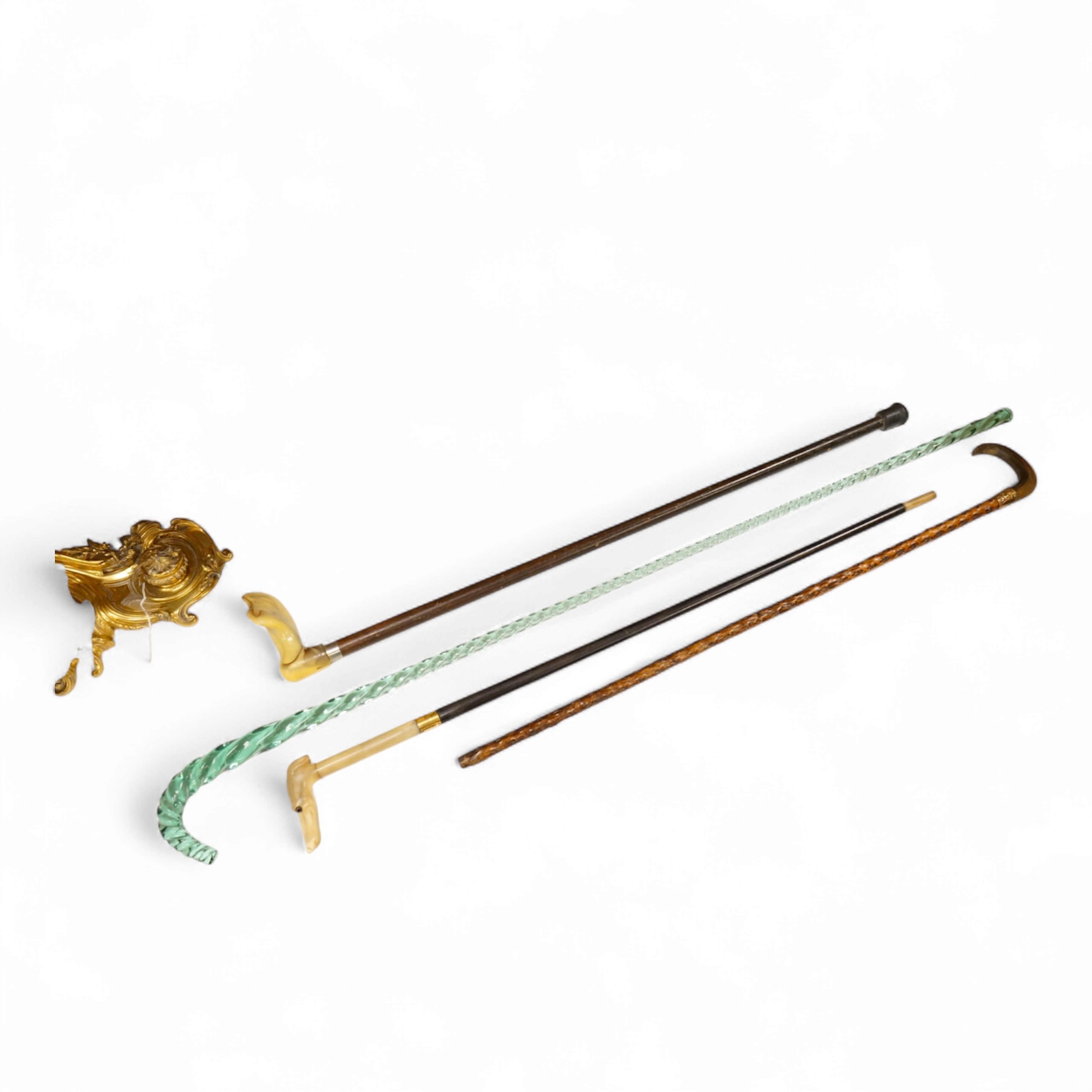 Four walking sticks to include a Brigg of London with carved horn handle in the form of a dogs head and a barley twist glass example, largest 123cm in length